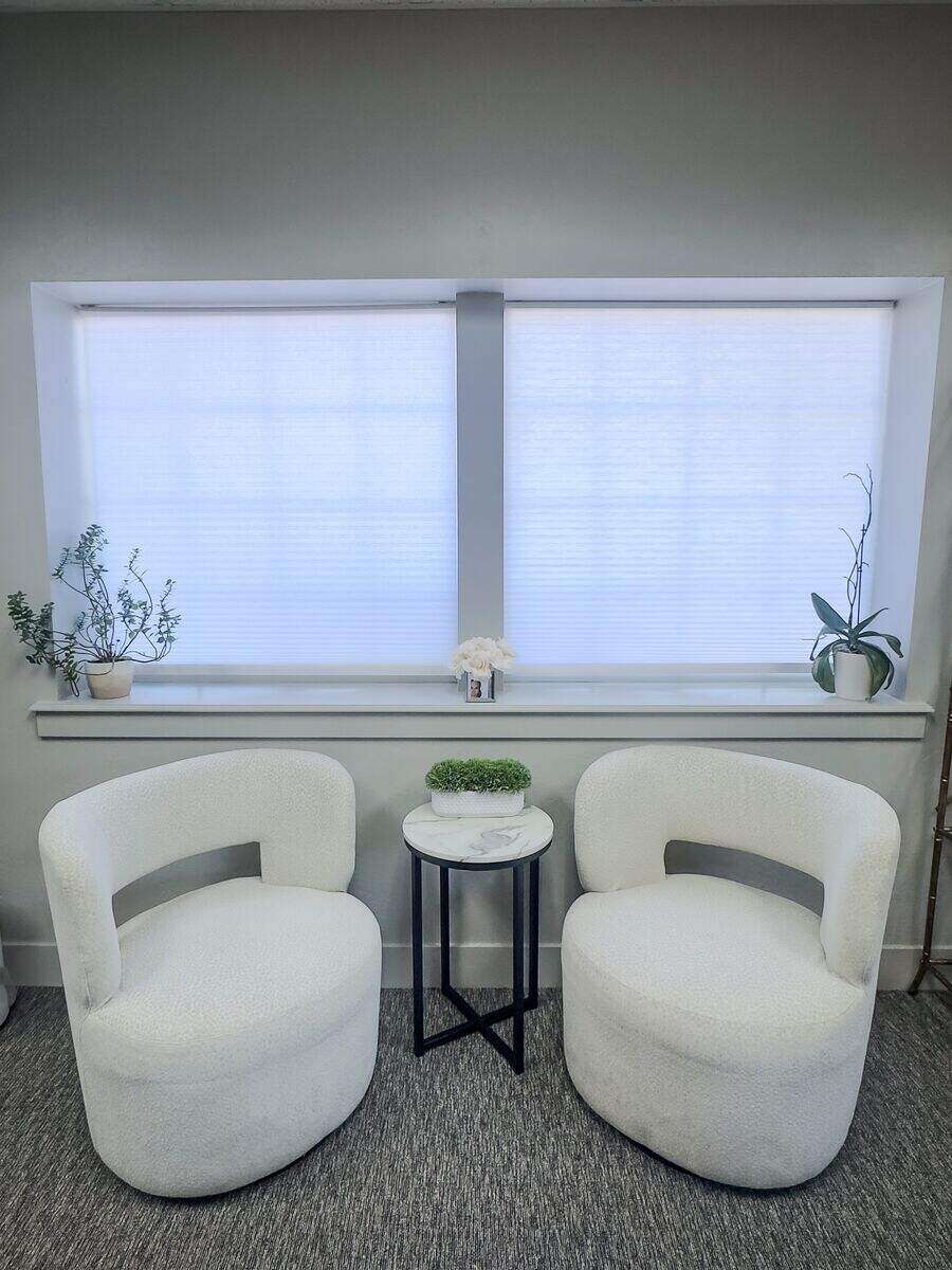 Bright seating area with bouclé chairs at Summit Aesthetics