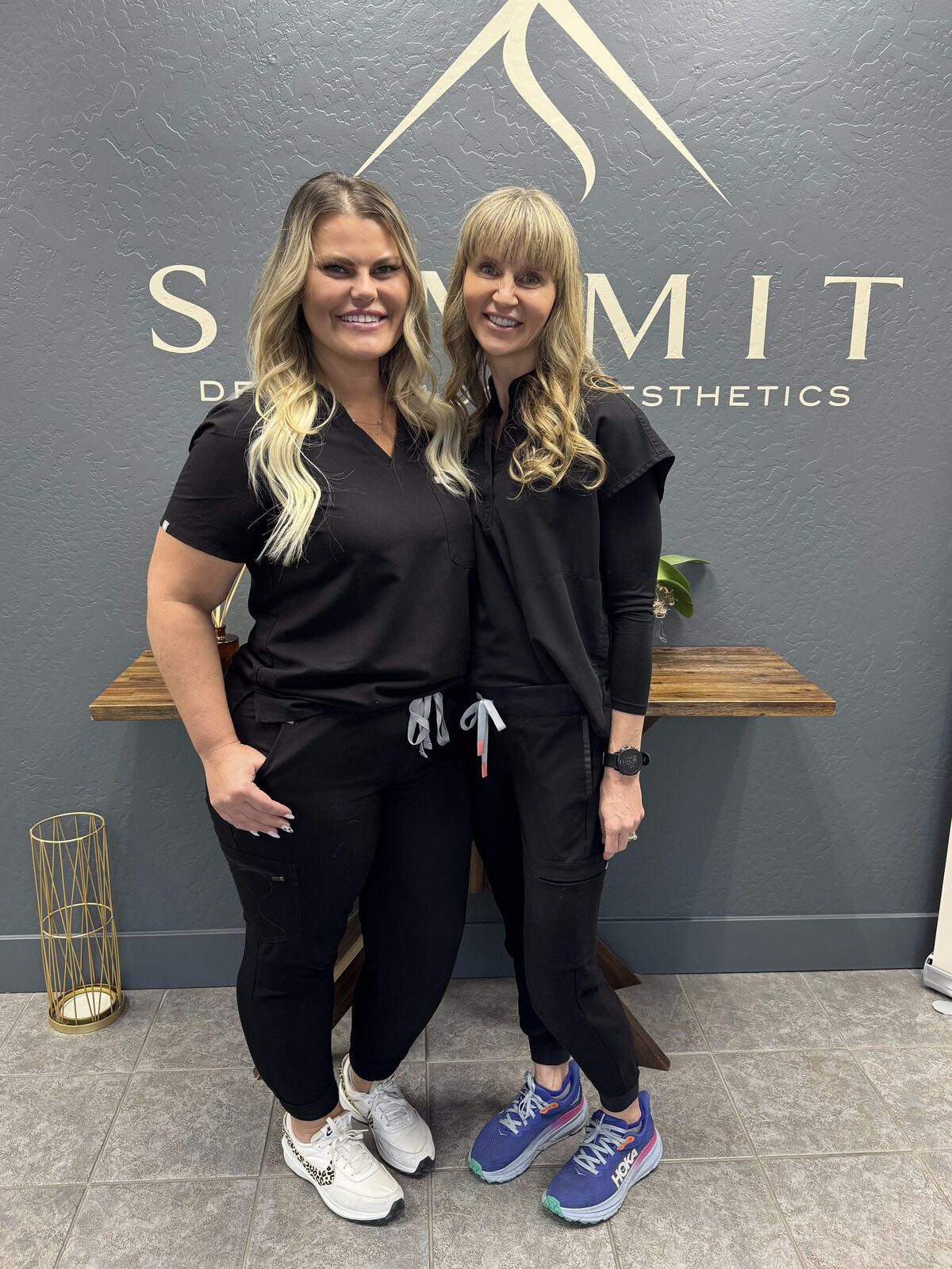 Summit team members in front of the Summit logo wall